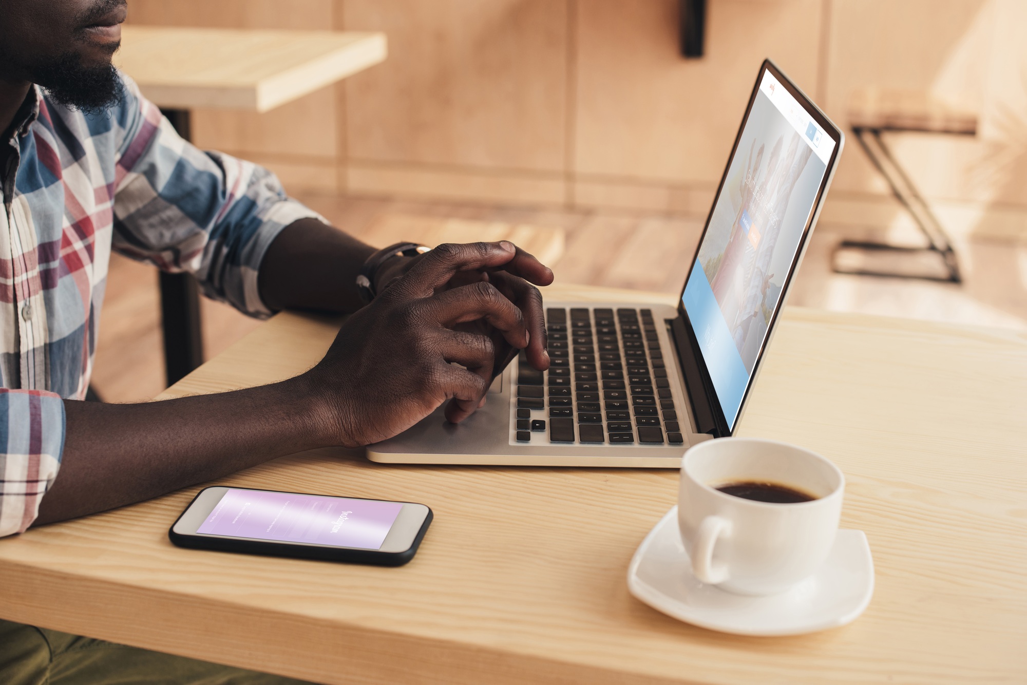 cropped view of african american man using smartphone with instagram and laptop with couchsurfing